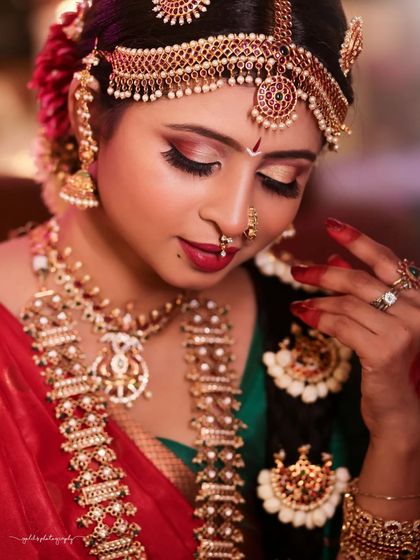 A detailed close-up of the bride's face, highlighting the traditional makeup and the exquisite craftsmanship of her jewelry.