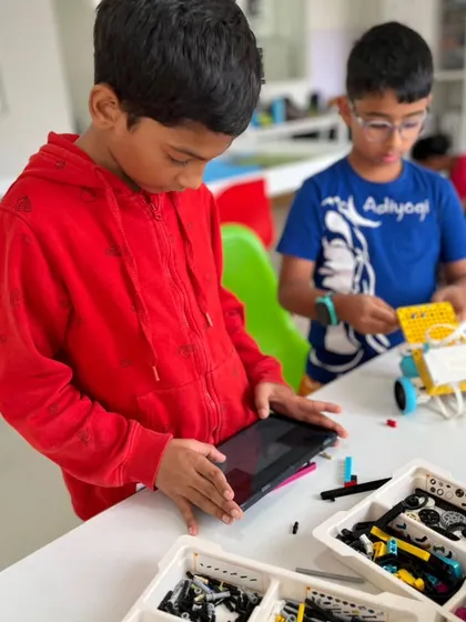 Precision is key in robotics competitions. A student carefully programs his robot using a tablet, preparing for the Indian Robotics Olympiad Techies category.