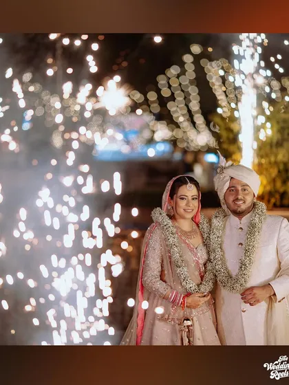 A beautiful portrait of the couple with a bokeh of sparklers, creating a magical and celebratory atmosphere.