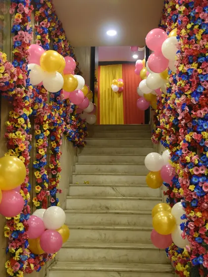 A creative way to decorate a staircase for a party. We used colorful artificial flower garlands mixed with clusters of balloons to transform this stairway into a beautiful floral pathway.