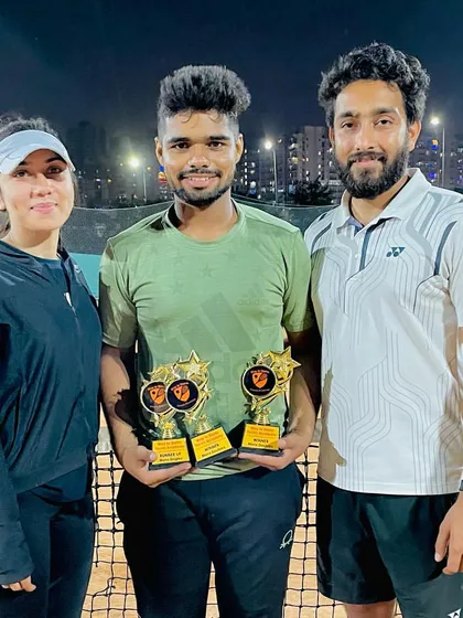 A winner's photo under the lights. Our tournaments often continue into the evening, showcasing the dedication of our players who compete with full energy, day or night.