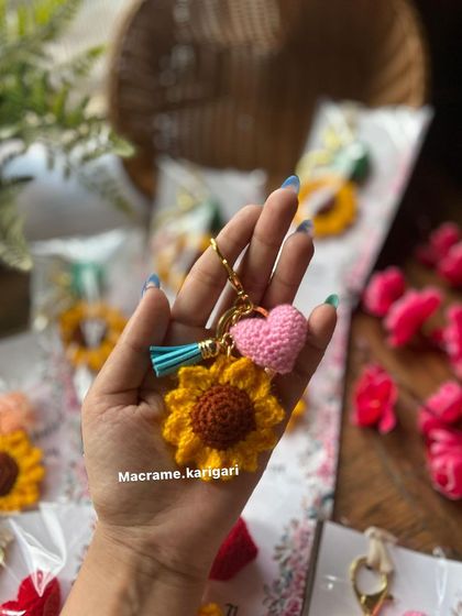 A close-up of the sunflower keychain with a pink heart. The combination of the bright flower and the soft heart makes it a truly lovely accessory.
