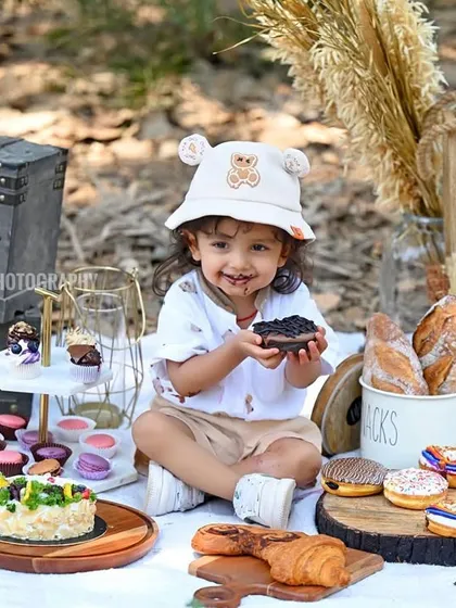 A cute and messy moment from the picnic shoot, with chocolate on the face and a happy smile.