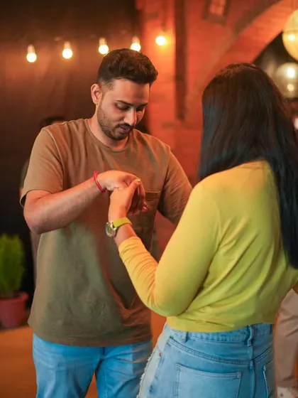 It all starts with learning to connect through your hands and movement. This image captures a moment of instruction where a student is learning the basics of leading in a partner dance, essential for a confident first dance.