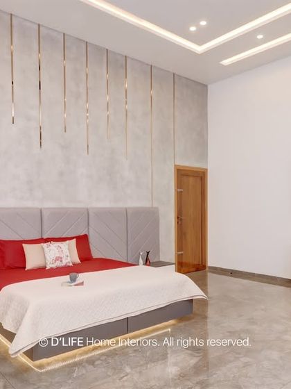 This spacious bedroom combines a grey upholstered headboard with a textured wall featuring gold strips. The integrated study nook and wardrobe offer complete functionality.