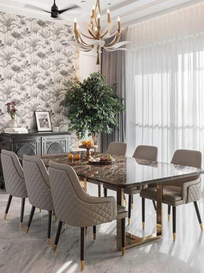 This dining area blends rustic charm with modern flair. The dark marble tabletop and quilted chairs are complemented by a tropical-print wallpaper and a statement chandelier, creating a unique and stylish space.