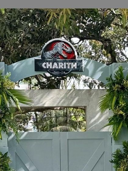The iconic Jurassic Park gates, personalized with the birthday boy's name, make for a grand and exciting entrance.