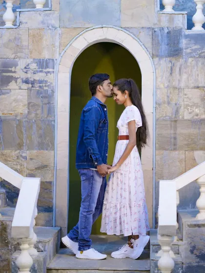 A tender forehead kiss in a stone archway. A beautiful, intimate moment captured during their casual pre-wedding shoot.
