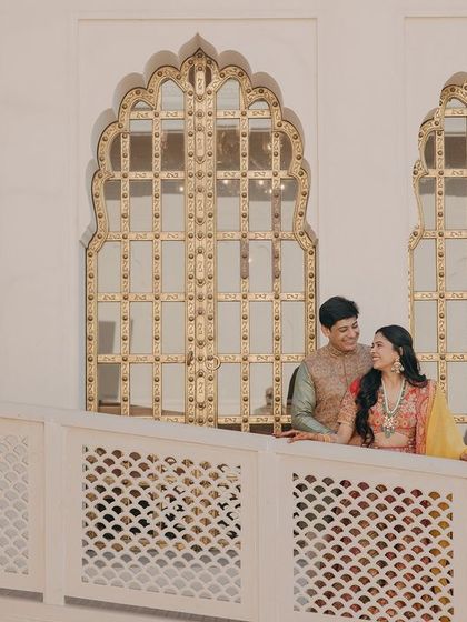 Tanya and Suyash share a moment on a balcony overlooking the beautiful architecture of The Oberoi Sukhvilas, a premier destination wedding venue in Chandigarh.