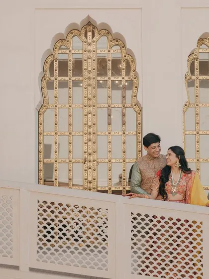 A quiet moment of connection on a balcony. This shot uses the architectural details of the venue to frame the couple, creating a classic and elegant portrait.