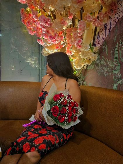 A side profile showing the fit of the floral dress. The spaghetti straps and neckline are flattering, and the print is bold without being overwhelming.
