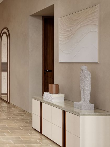 The console area in the Siroi Lily bedroom is a curated moment. The neutral, textured walls provide a backdrop for a simple white console, abstract art, and a sculptural object, reflecting a philosophy of quiet, considered design.