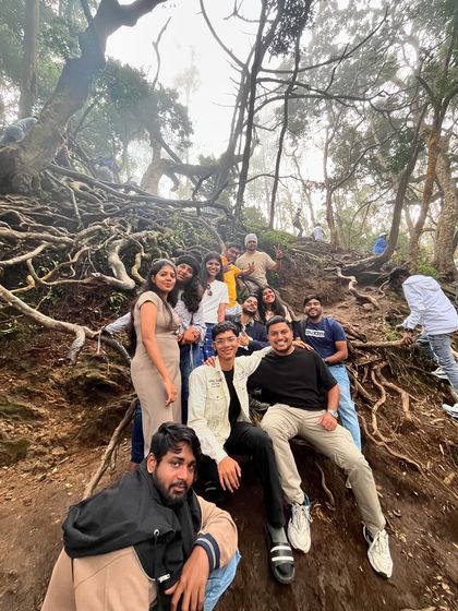 The group finding a unique spot among the tree roots for a memorable photo.