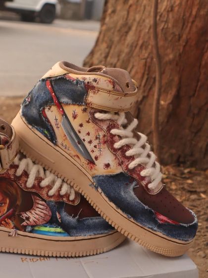 This angle shows the details on the side of the Chucky sneakers, including his signature knife breaking through the Nike swoosh and blood spatter effects for a gory touch.