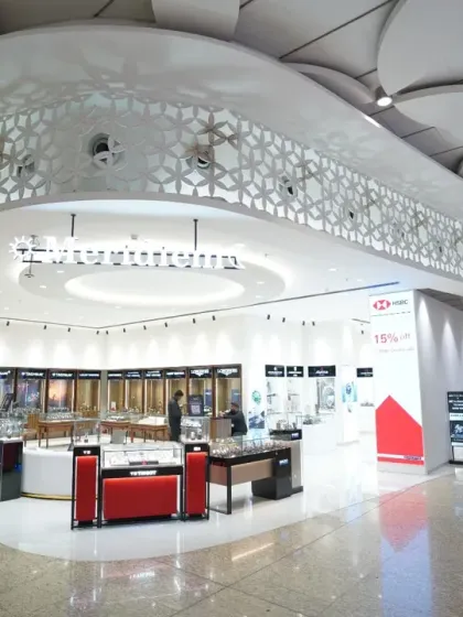 The clean lines and modern architecture of a luxury watch and jewelry store. This wide shot emphasizes the store's design, from the curved ceilings to the strategic placement of display cases.