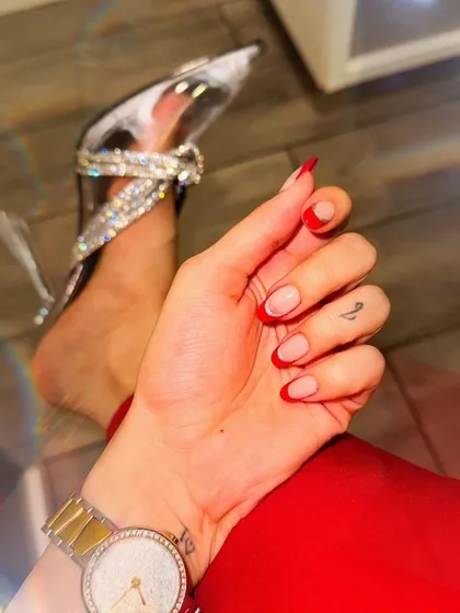 Red hot and ready for anything. This design features a sharp, clean red French tip on short, natural-looking round nails, paired perfectly with some killer heels.