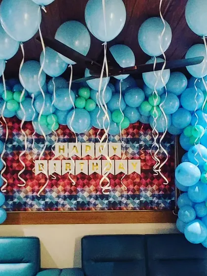 A birthday decoration featuring a blue organic balloon garland. The varying shades of blue and the free-form design create a modern and stylish look for the party.