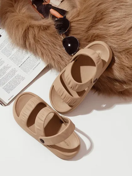 A flat-lay composition featuring beige sandals, a magazine, and sunglasses on a faux fur rug. This type of styling creates a complete aesthetic, selling a lifestyle, not just a product.