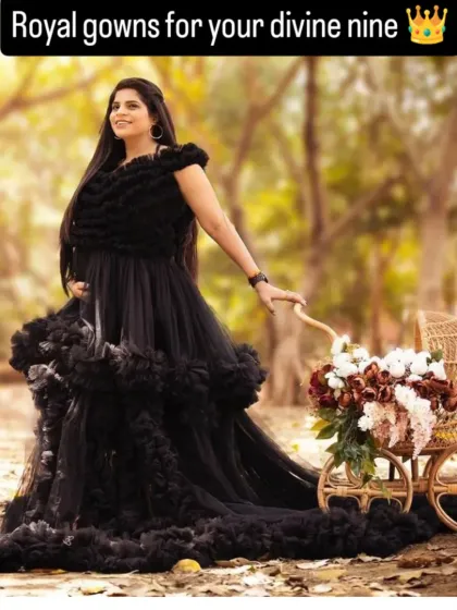 An outdoor shot featuring our black ruffled gown. The natural setting contrasts beautifully with the gown's dramatic elegance, perfect for a unique maternity shoot.