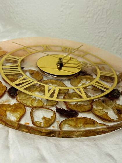 A side view of the fruit slice clock, showing the depth and texture of the preserved fruit. Each slice is carefully placed to create a beautiful and balanced composition.