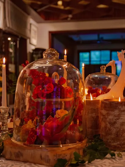 A floral arrangement captured under a glass cloche, creating a beautiful still-life moment within the larger design. This technique elevates the flowers, presenting them as precious objects of art.
