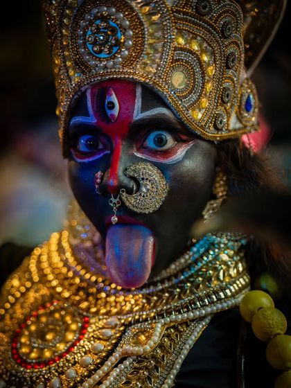 A direct, powerful portrait of a performer. The intense gaze, detailed makeup, and traditional jewelry tell a story of devotion and power.