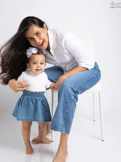 Twinning in denim. This mother and daughter share a beautiful, happy moment, showcasing their special bond in a fun, casual portrait.