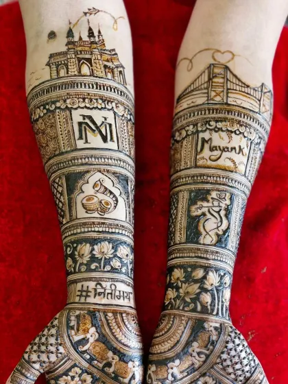 A detailed view of the skyline mehendi, showing the Gateway of India and Bandra-Worli Sea Link with the couple's initials and names.