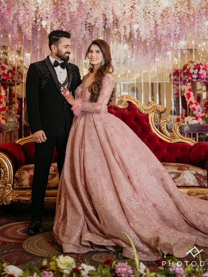 Here is a beautiful client couple celebrating their engagement. She is wearing my popular dusty rose ball gown, which features delicate feather-cuffed sleeves and a sparkling, full A-line skirt. This image captures the romantic, fairytale atmosphere I strive to create for your special moments.