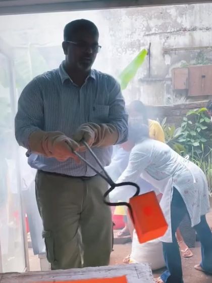 Another angle of me removing a glowing piece from the kiln. The energy and focus during a Raku firing are intense.