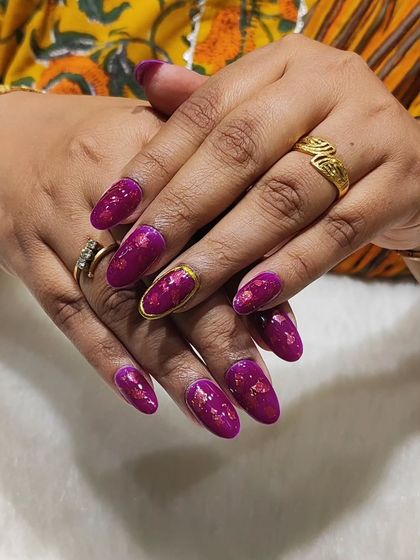 Luxury in a manicure. This set features a bold magenta chrome foil on almond-shaped nails, with one accent nail featuring a gold chrome outline. The foil gives a beautiful, textured metallic finish.