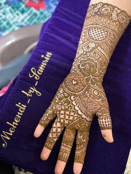A close-up of a single hand, showing the detailed checkerboard and floral patterns.