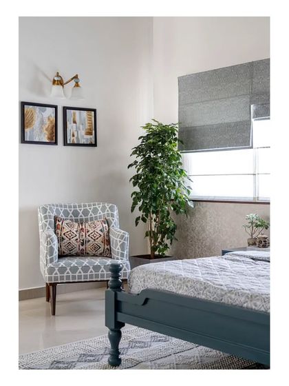 A comfortable lounge chair in the corner of the master bedroom, showcasing the use of layered patterns in the upholstery and rug to add visual interest without overwhelming the serene space.