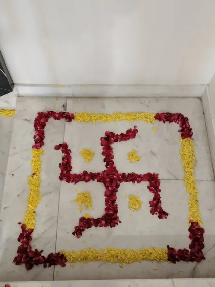 A traditional swastika symbol made from flower petals for an auspicious welcome.