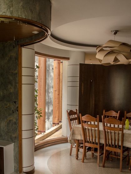 Another view of the dining space, highlighting the use of rich wood tones and green stone to create a warm and sophisticated atmosphere.