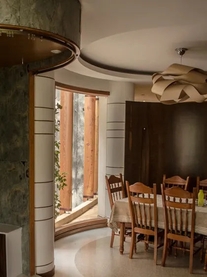Another view of the dining space, highlighting the use of rich wood tones and green stone to create a warm and sophisticated atmosphere.