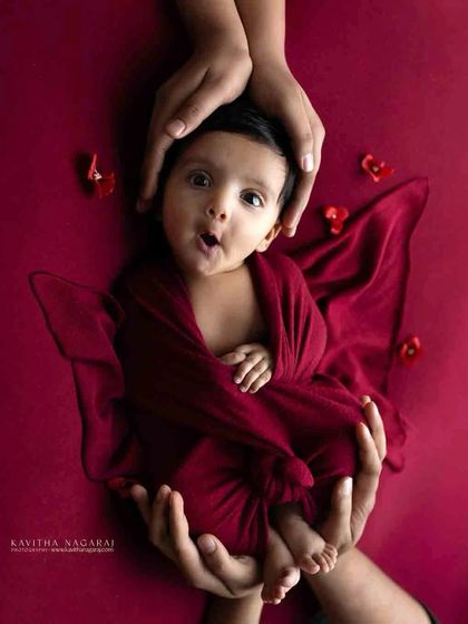 A three-month-old baby gives a surprised "hello" to the camera. Even older babies can have their newborn-style portraits, full of personality and charm.