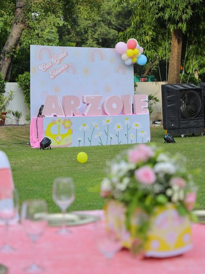 A wide shot of the personalized name display on the lawn, with a themed centerpiece in the foreground. This shows the beautiful layering of decor elements.