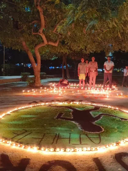 Another view of our creative rangoli, with the word "Athlete" beautifully lit by diyas.