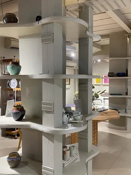 Detail of the custom shelving we designed for the JOSMO store. The organic, flowing shapes of the shelves wrap around existing columns, transforming structural elements into functional and sculptural display units.