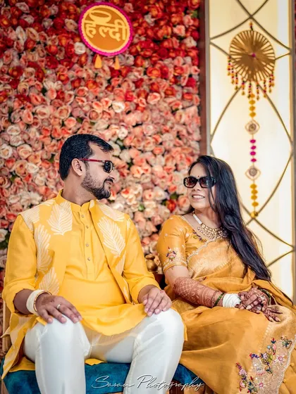 A cool and stylish portrait of the couple wearing sunglasses during their sunny outdoor Haldi ceremony.