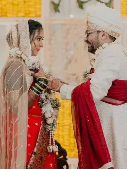 A candid moment during a Maharashtrian wedding, showcasing the traditional attire and the happy interactions between the couple.