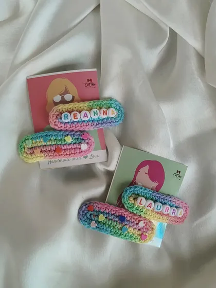 A close-up of our personalized name clips for 'Reanna' and 'Laura'. The quality of the crochet and the colorful letter beads make them a standout accessory.