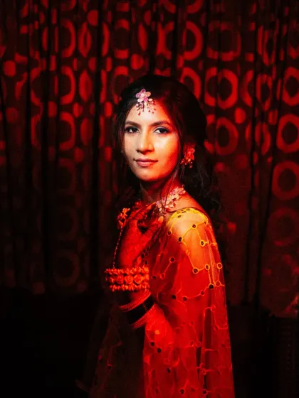 A dramatic bridal portrait using creative red lighting and shadows. This artistic approach creates a bold and unconventional image that stands out, highlighting the bride's features in a unique way.
