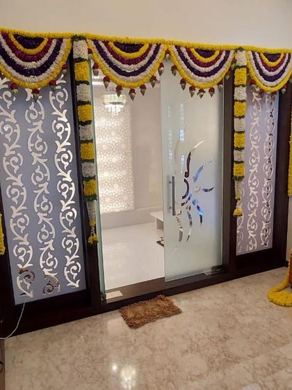 Simple and elegant door decoration using marigold and jasmine garlands. This style is perfect for adding a festive touch to any home ceremony or pooja.