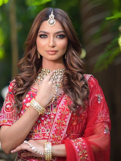 A complete bridal look featuring a heavy, gold-plated Kundan necklace, haath phool, and maang tikka, all available for rent.