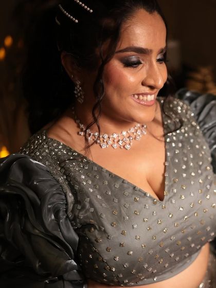 A symphony of elegance and dreams. This bride's sangeet makeup features a dramatic smokey eye that complements her glamorous grey lehenga.