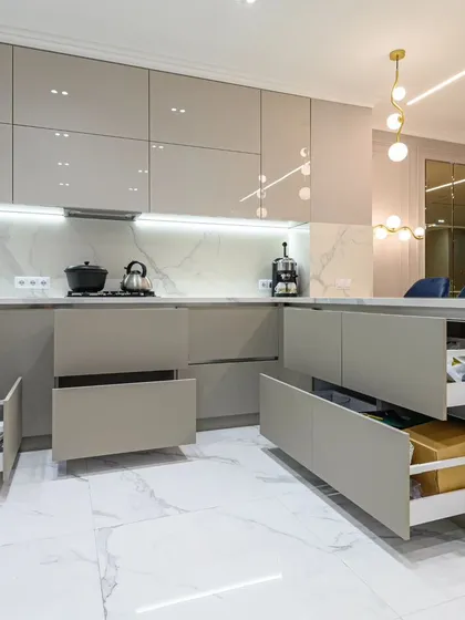 A modern kitchen is the heart of the home, and we design them for both beauty and function. This space features a minimalist aesthetic with handle-less high-gloss cabinets, a marble-finish countertop, and smart, soft-close drawers that reveal maximum storage, ensuring a clutter-free and premium cooking experience.