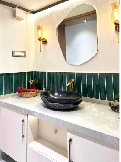 Another view of the passage vanity, highlighting the emerald green tile backsplash and the unique, natural form of the stone basin.