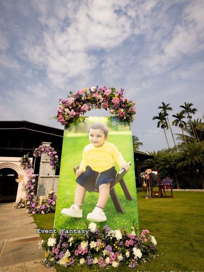 A large, cheerful photo cutout of the birthday boy, Dhanvith, greets guests at his naming ceremony. These personal touches always bring a smile to everyone's face.